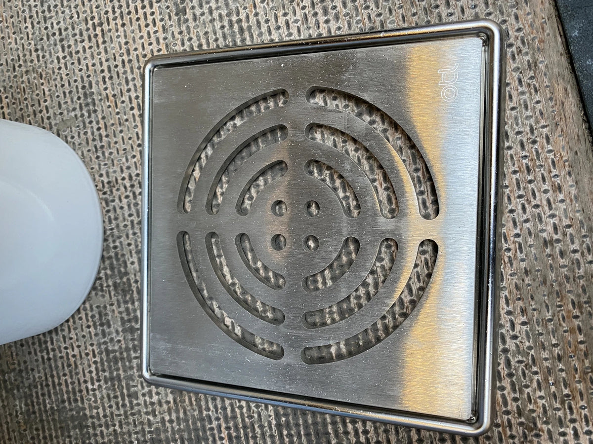 OTL stainless-steel shower drain grate close-up