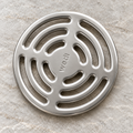 Wedi round stainless steel drain grate - clean showroom view