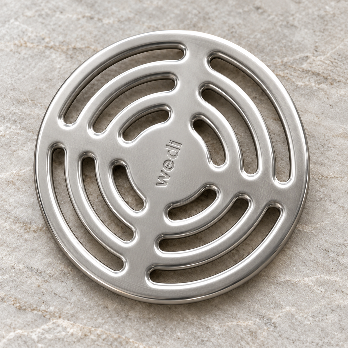 Wedi round stainless steel drain grate - clean showroom view